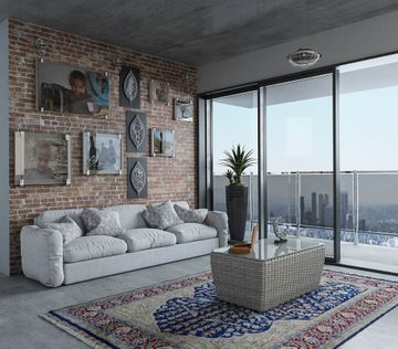 Lys stue med sofa, teppe og dekor av bilder