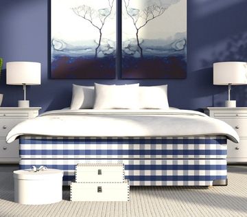 Stort lyse blått soverom med lyse nattbord på hver sin side